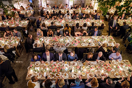People sitting and eating at long tables in our private event venue near New York City.