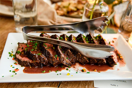 Sliced steak and serving tongs at our party hall near New York City.