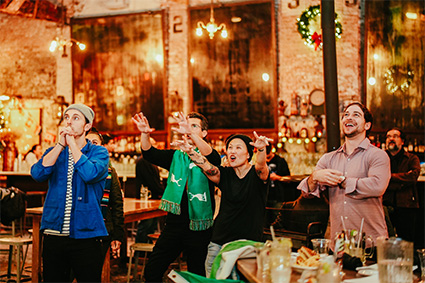 Group of friends watching a sports game and enjoying drinks at our West Village, NYC sports bar.